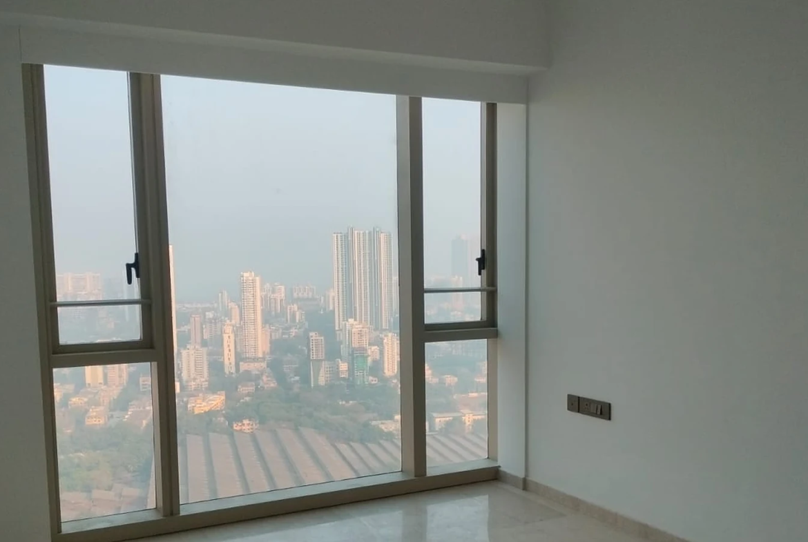 Master bedroom with large picture window, marble flooring and high-rise city view in 3 BHK at Lodha Park Tower Adrina, Worli