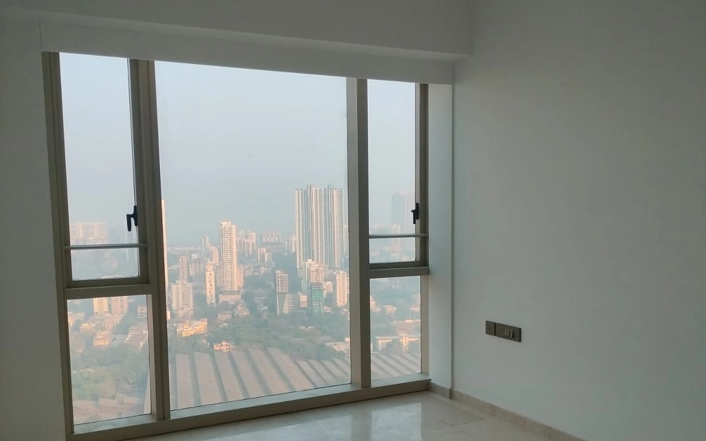 Master bedroom with large picture window, marble flooring and high-rise city view in 3 BHK at Lodha Park Tower Adrina, Worli
