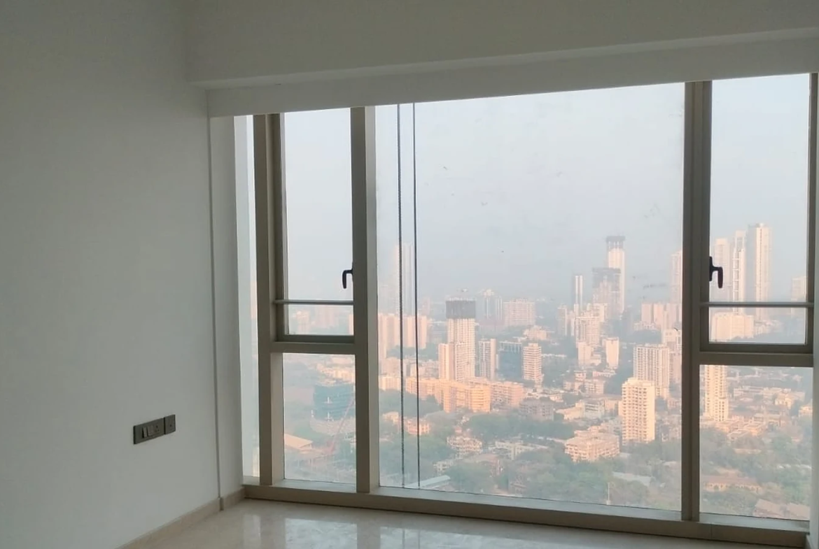 Bedroom with marble flooring, split AC and floor-to-ceiling city view window in 3 BHK for rent at Lodha Park Tower Adrina, Worli