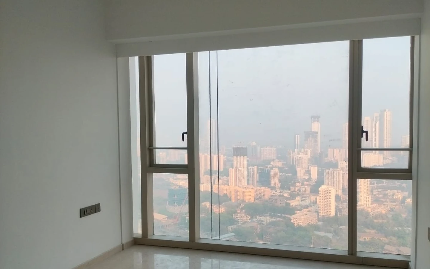 Bedroom with marble flooring, split AC and floor-to-ceiling city view window in 3 BHK for rent at Lodha Park Tower Adrina, Worli