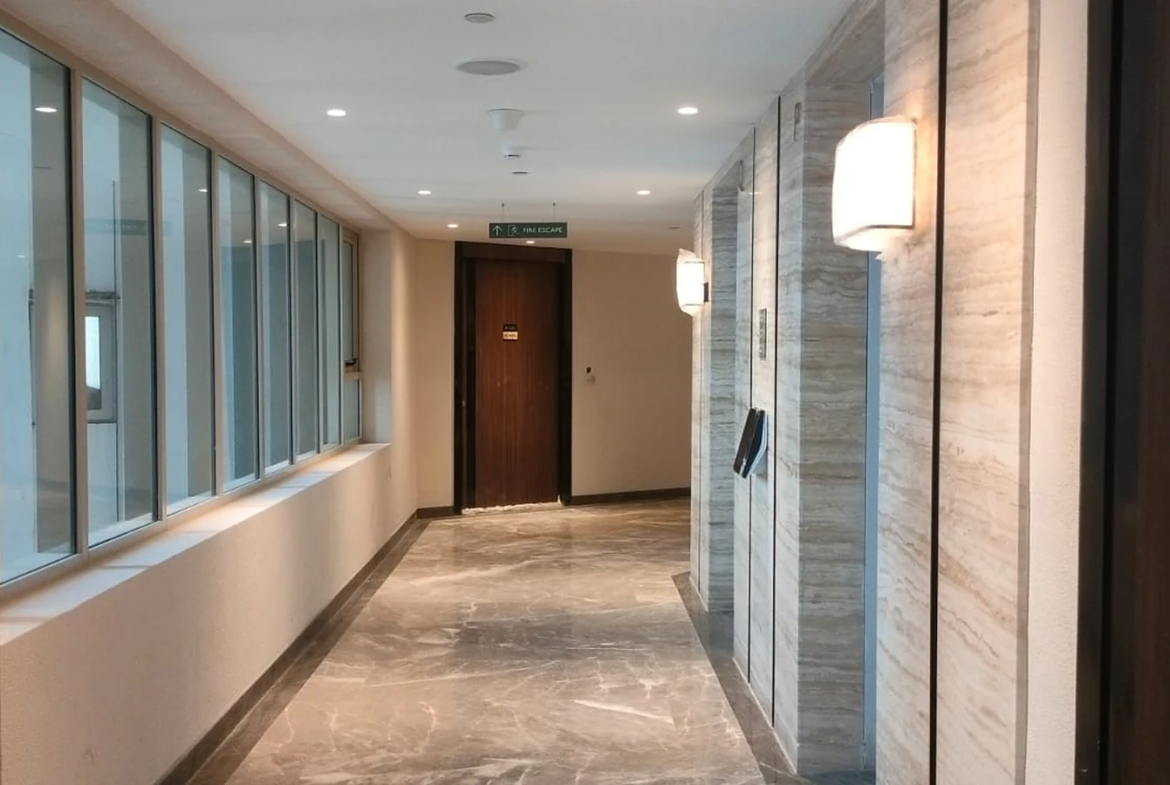 Marble-clad lift lobby and corridor with natural light at Lodha Park Tower Adrina, Worli