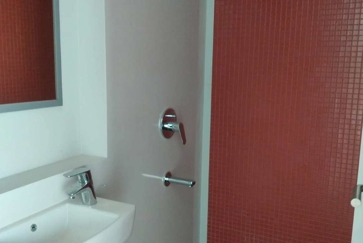 Bathroom with red mosaic tile shower wall, rain shower and wall-mounted basin in 3 BHK at Lodha Park Tower Adrina, Worli