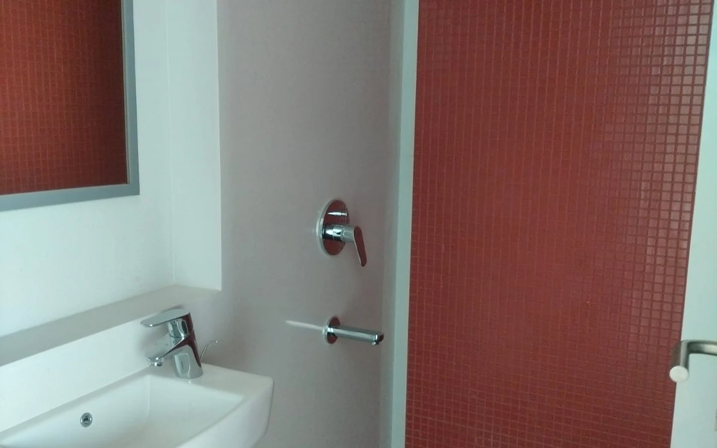 Bathroom with red mosaic tile shower wall, rain shower and wall-mounted basin in 3 BHK at Lodha Park Tower Adrina, Worli