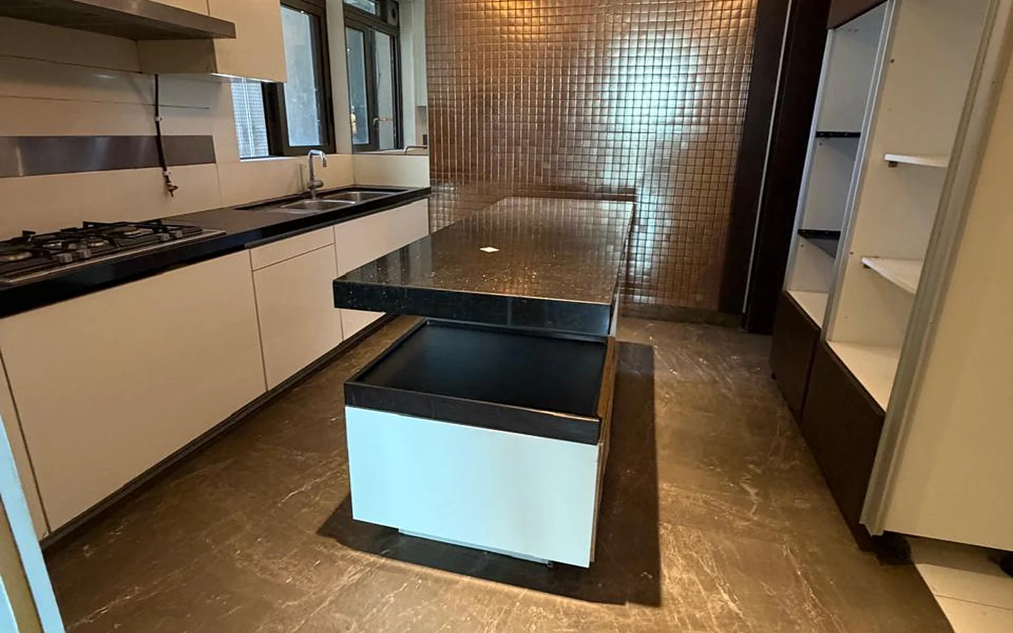 Lodha Trump Tower 4 BHK for Sale – Modular Kitchen with Island Modular kitchen with granite island counter, mosaic feature wall, cove lighting and built-in hob in 4 BHK at Lodha Trump Tower, Worli