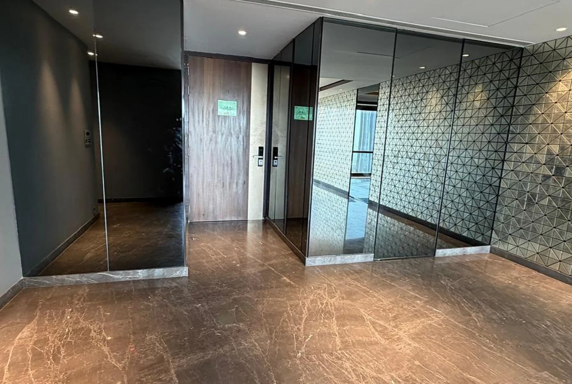 Entrance foyer with smoked glass panels, geometric feature wall and marble flooring in 4 BHK at Lodha Trump Tower, Worli