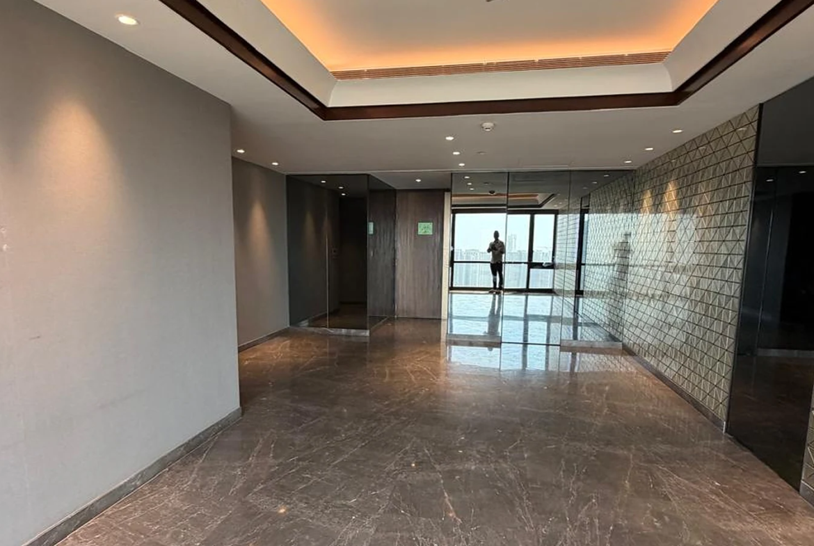 Wide hallway with cove-lit tray ceiling, mirror panels and marble flooring in 4 BHK at Lodha Trump Tower, Worli