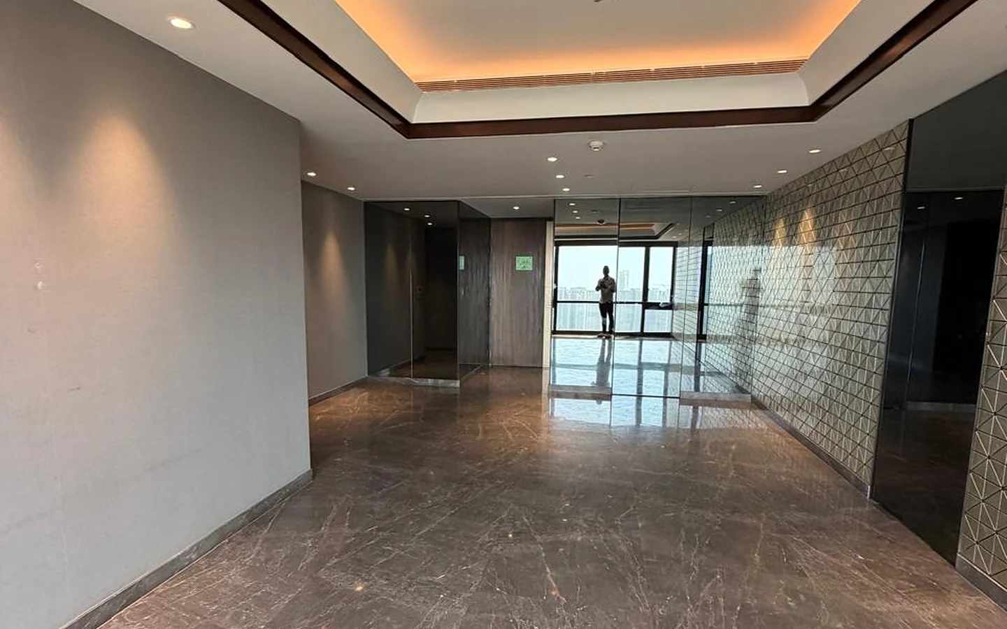 Lodha Trump Tower 4 BHK for Sale – Hallway with Cove Lighting Wide hallway with cove-lit tray ceiling, mirror panels and marble flooring in 4 BHK at Lodha Trump Tower, Worli