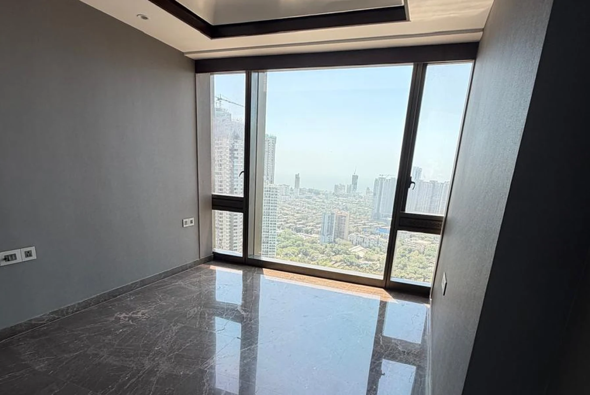 Master bedroom with tray ceiling, marble flooring and large window overlooking the city and sea in 4 BHK at Lodha Trump Tower, Worli