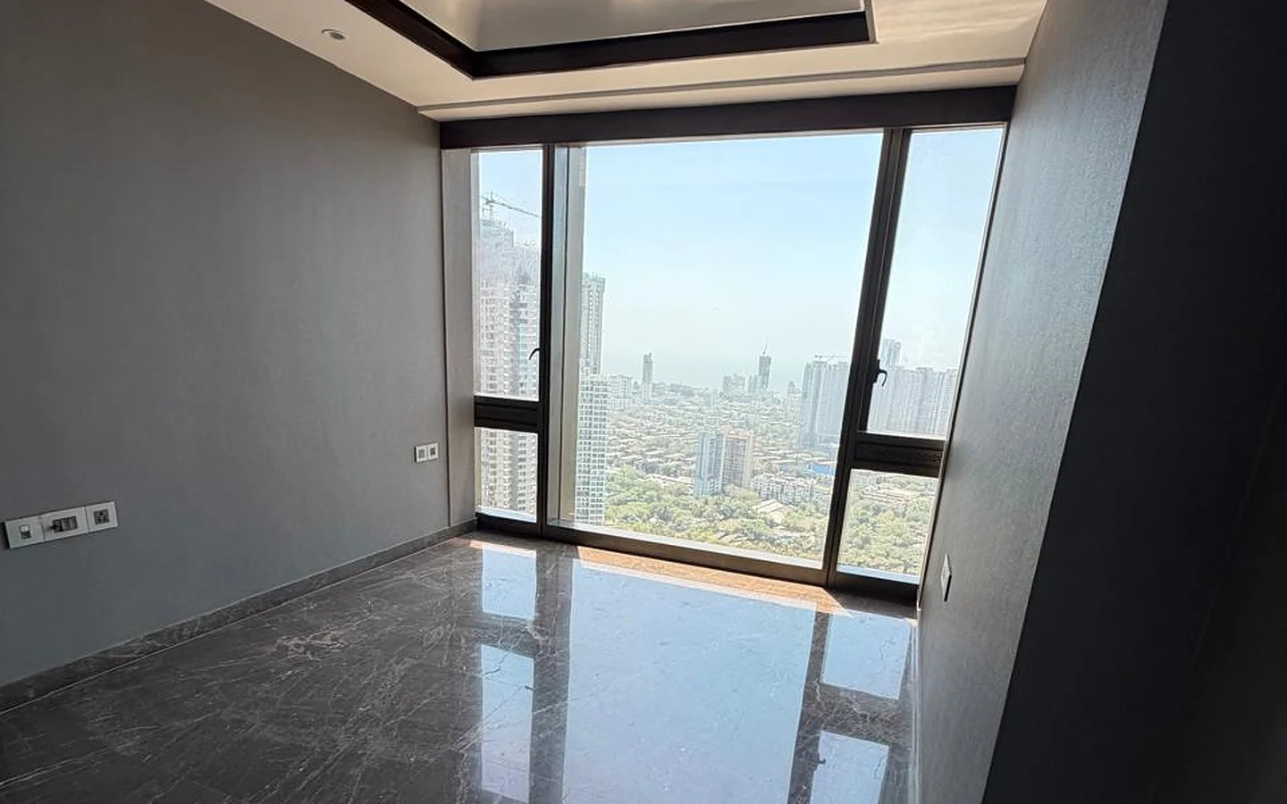 Lodha Trump Tower 4 BHK for Sale – Master Bedroom with Sea and City View Master bedroom with tray ceiling, marble flooring and large window overlooking the city and sea in 4 BHK at Lodha Trump Tower, Worli