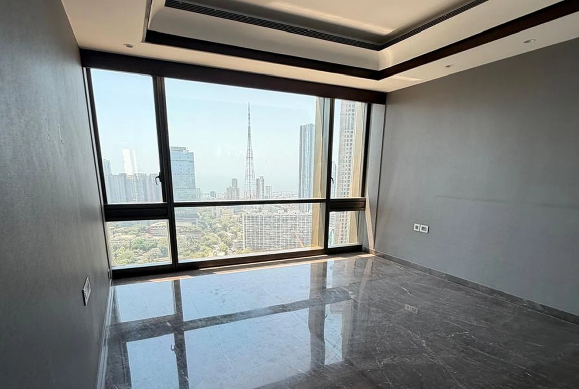 Bedroom with wide picture window, marble flooring and Mumbai skyline view on the 40th floor at Lodha Trump Tower, Worli