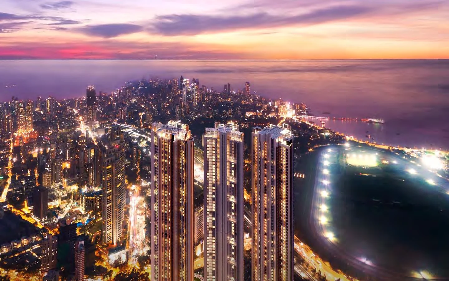Night aerial view of Piramal Mahalaxmi towers beside the illuminated Mahalaxmi Racecourse, South Mumbai