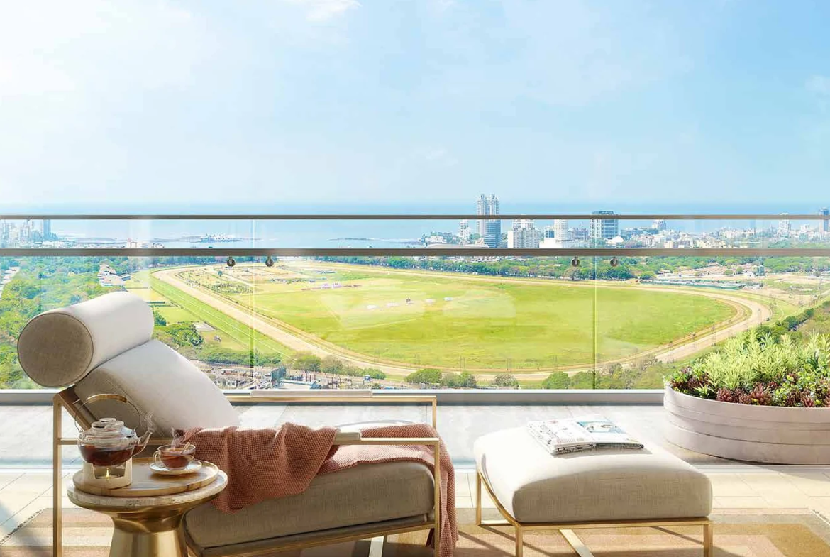 Residence balcony with lounger overlooking Mahalaxmi Racecourse and the sea at Piramal Mahalaxmi, South Mumbai