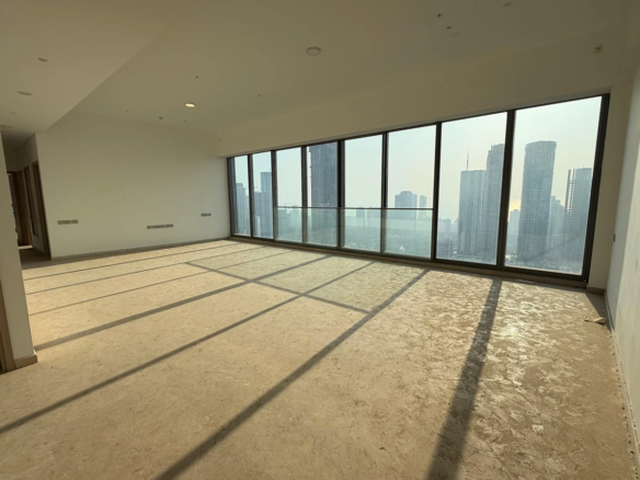 Spacious living room with full-width floor-to-ceiling glass windows and Mumbai skyline view in 5 BHK at Rustomjee Crown, Prabhadevi
