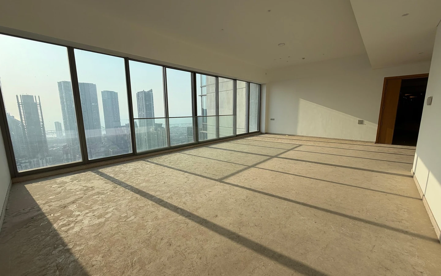 Living room with panoramic glass windows overlooking the Arabian Sea and Bandra-Worli Sea Link in 5 BHK at Rustomjee Crown, Prabhadevi