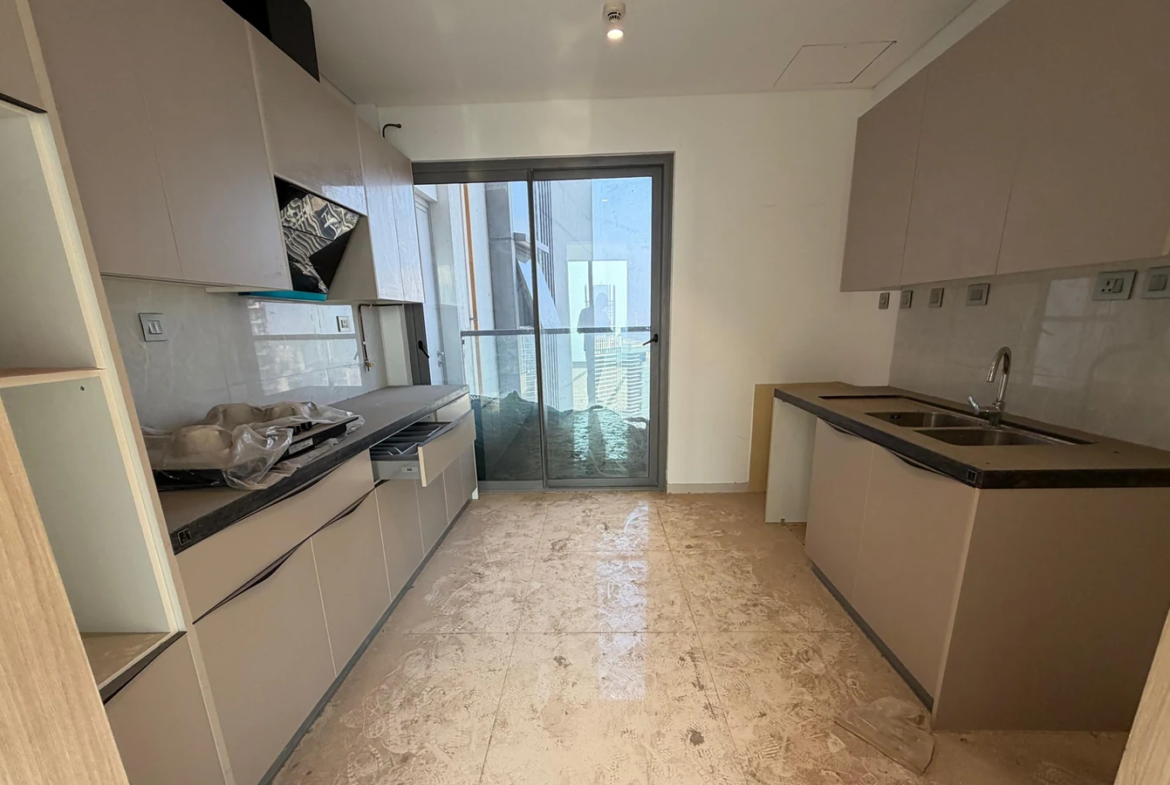 Modular kitchen with built-in cabinets, hob, chimney, double-bowl sink and balcony access in 5 BHK at Rustomjee Crown, Prabhadevi