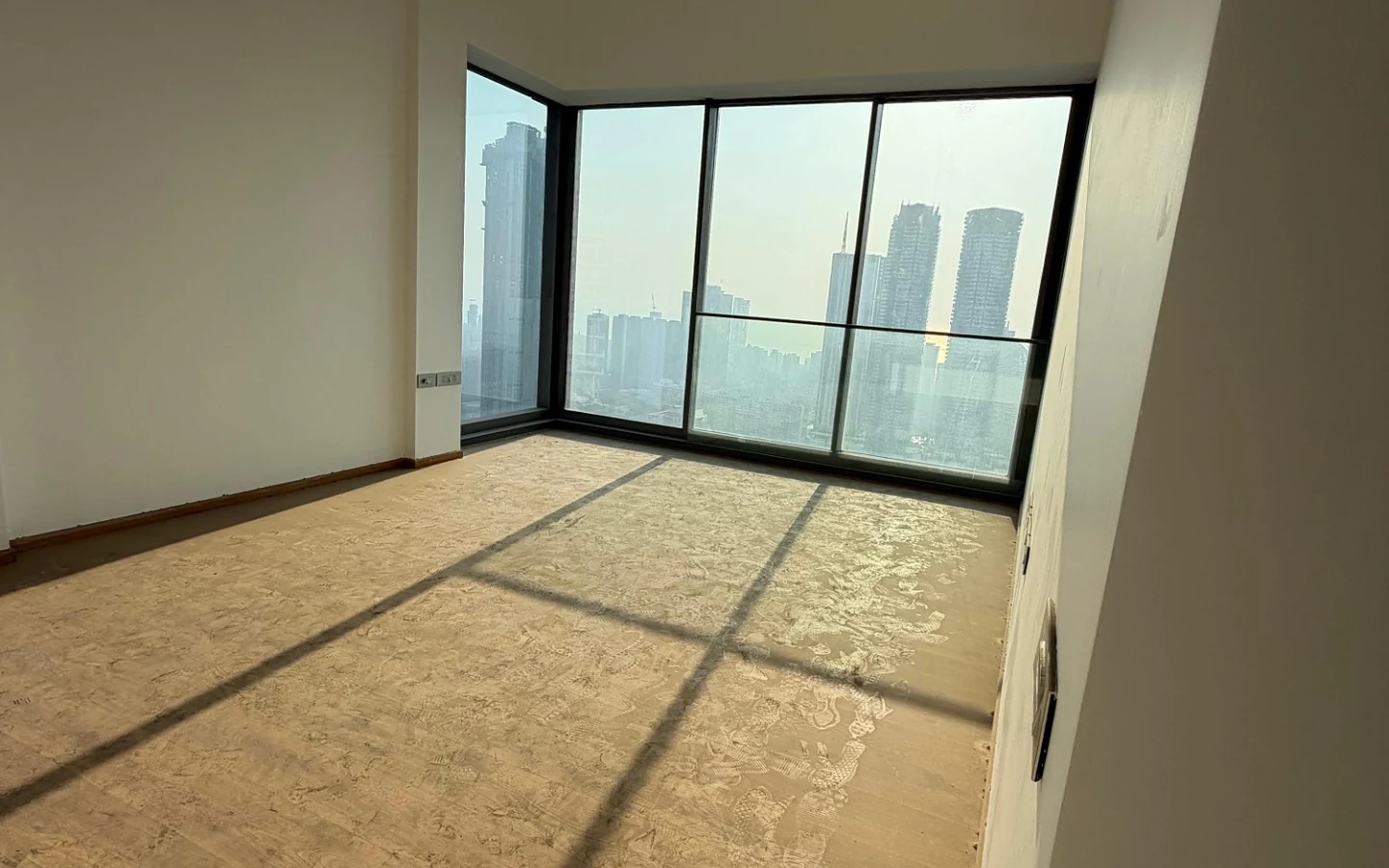 Bedroom with corner glass windows and Mumbai skyline view on the 45th floor at Rustomjee Crown, Prabhadevi
