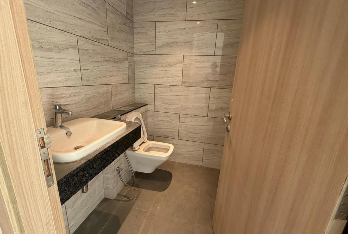 Powder room with granite counter basin and wall-hung WC in 5 BHK at Rustomjee Crown, Prabhadevi