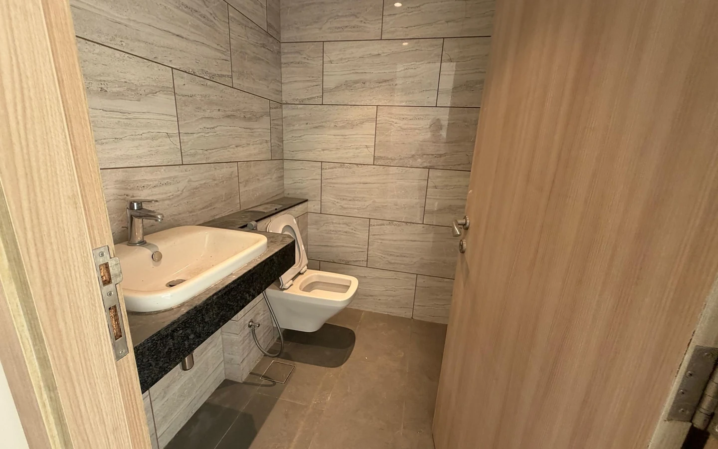 Powder room with granite counter basin and wall-hung WC in 5 BHK at Rustomjee Crown, Prabhadevi